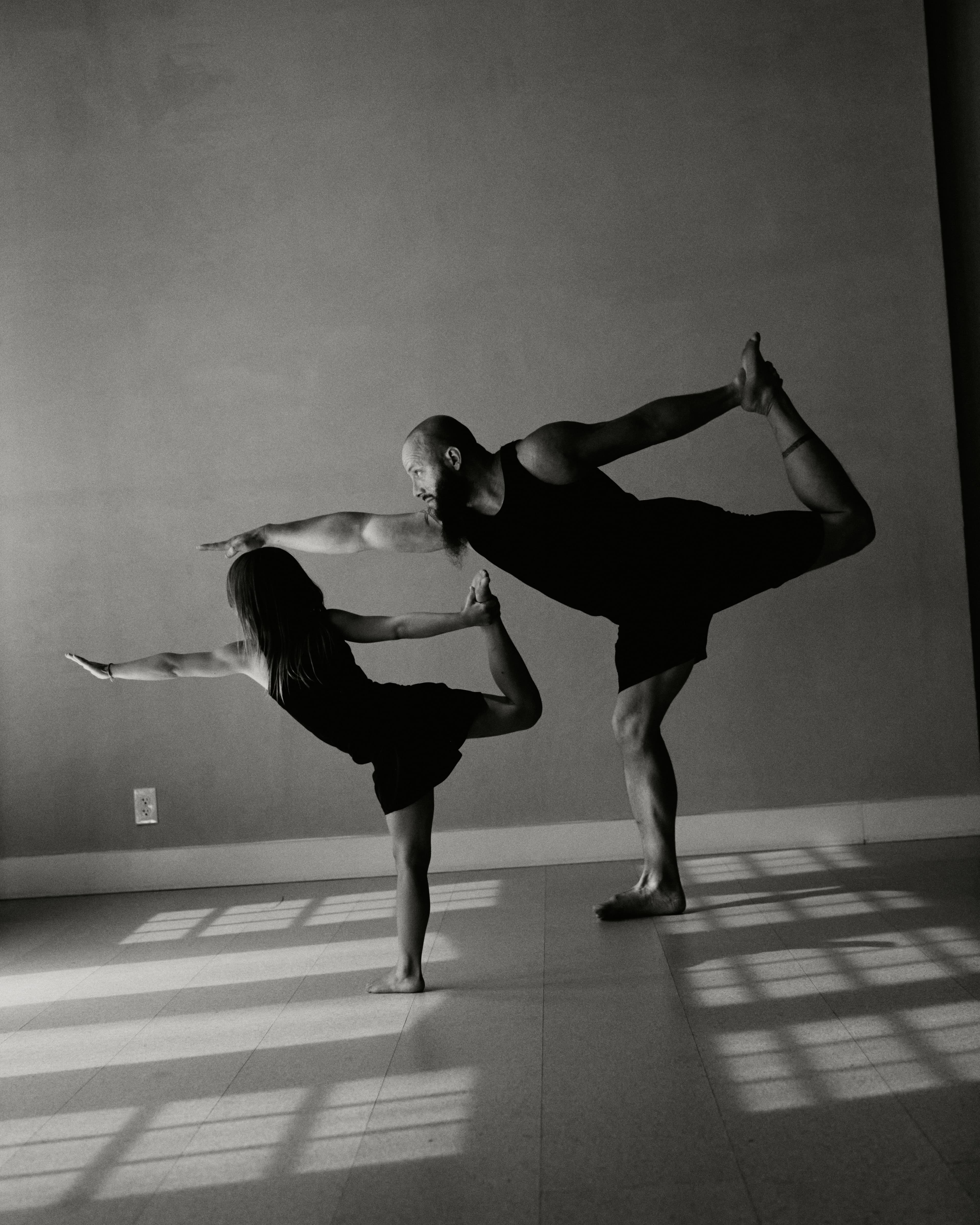 Two yoga practitioners in dancer pose in the studio