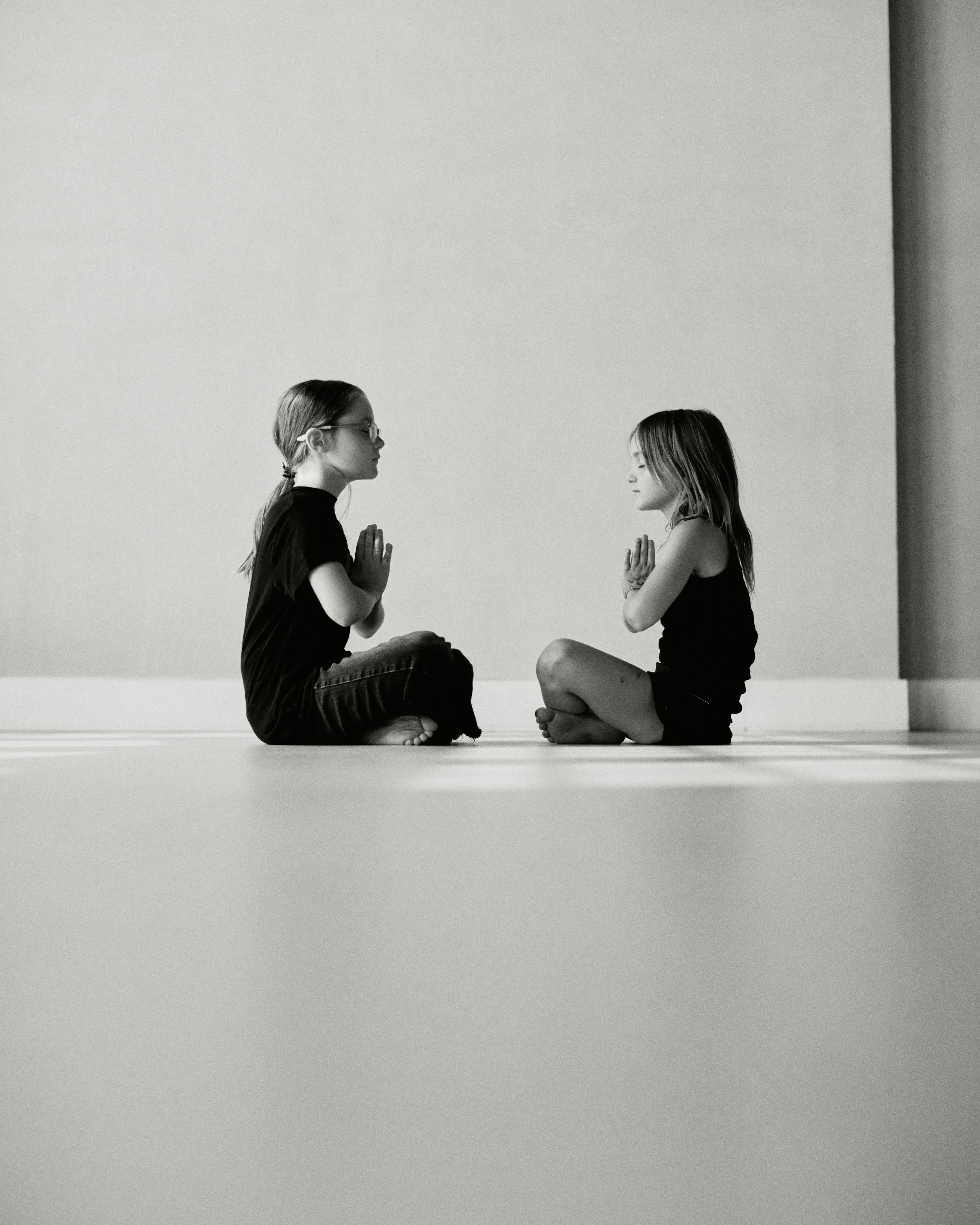 Two children practicing yoga facing each other
