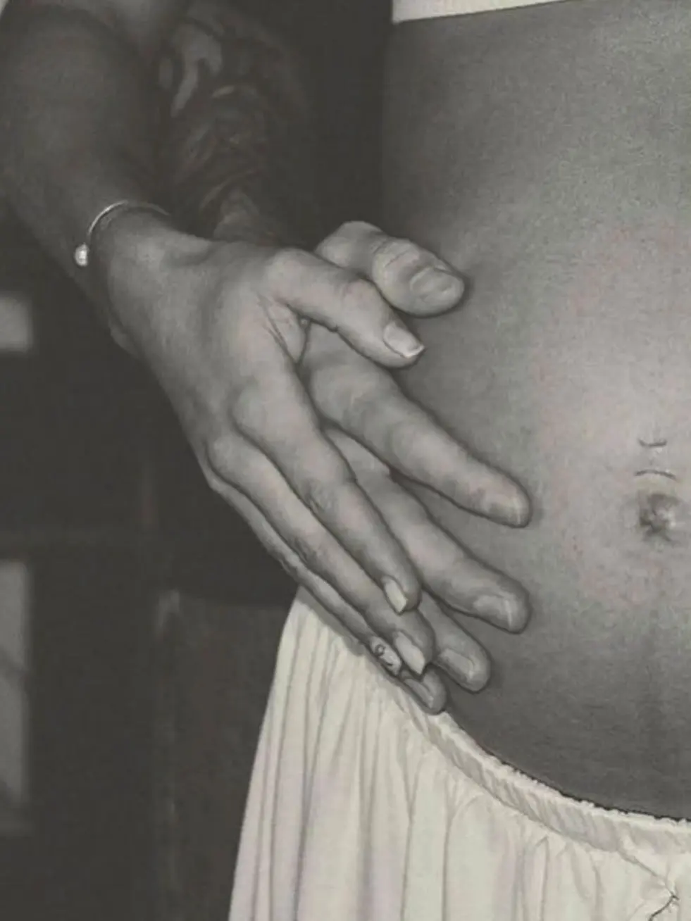 An expecting student resting both hands on her belly
